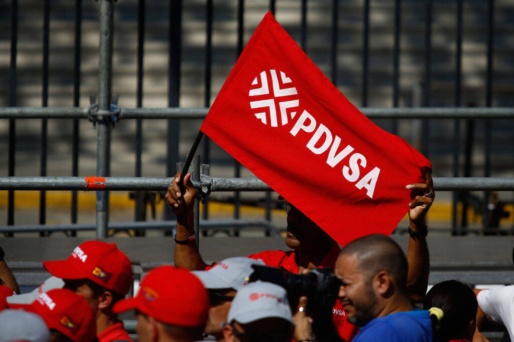 A Chavista waves a flag with the Petroleos de Venezuela SA (PDVSA) logo at a rally in Caracas, Venezuela, on January 31, 2019. Photo: Marcus Bello/Bloomberg/file photo.