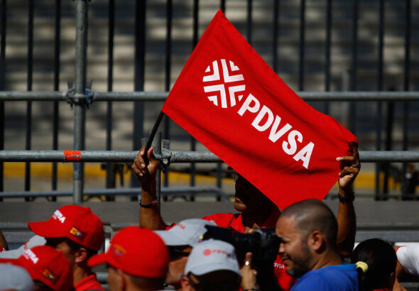 A Chavista waves a flag with the Petroleos de Venezuela SA (PDVSA) logo at a rally in Caracas, Venezuela, on January 31, 2019. Photo: Marcus Bello/Bloomberg/file photo.