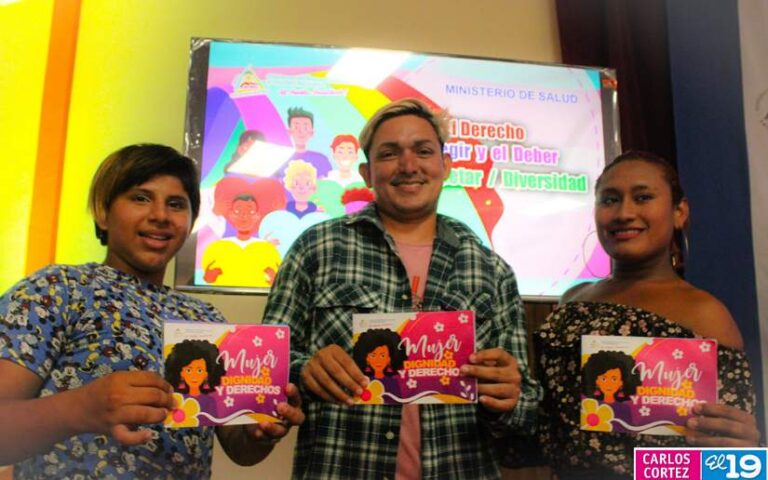 Three young people each holding the Diversity booklet, which says: Women, Dignity and Law. Photo: El 19 Digital.