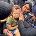 Mourners comfort a young girl at the funeral of Palestinians killed in Israeli strikes in Deir el-Balah, central Gaza, on June 28. Photo: Reuters.