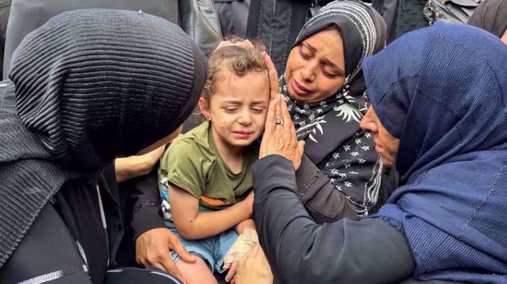 Mourners comfort a young girl at the funeral of Palestinians killed in Israeli strikes in Deir el-Balah, central Gaza, on June 28. Photo: Reuters.