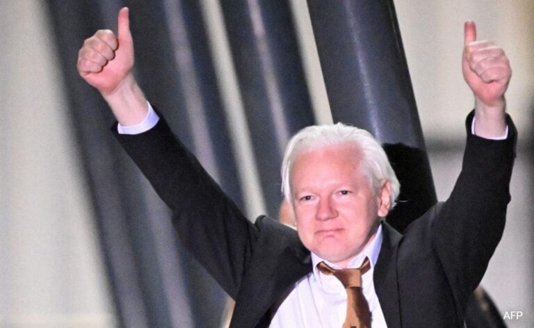 Julian Assange with his fists up on his arrival in Australia after almost 11 years of United States persecution for revealing the atrocities of the US military in Iraq and Afghanistan. Photo: AFP.