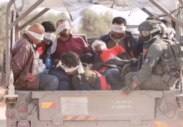 Israeli soldiers tranfer Palestinians out of the Gaza Strip, on November 21, 2023. Photo: AFP.