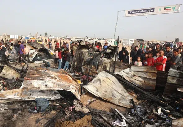 Palestinians contemplating in astonishment the devastation of Israeli bombing on a camp for internally displaced people in Rafah, Gaza, on May 27. Photo: Eyad Baba/AFP/Getty Images.