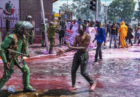 Kenyan police officers intervene in people during a protest against the tax hikes in planned 'Finance Bill 2024' as they march to the parliament building in Nairobi, Kenya on June 25, 2024. Photo: AA.