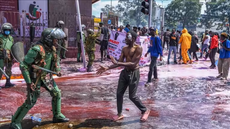 Kenyan police officers intervene in people during a protest against the tax hikes in planned 'Finance Bill 2024' as they march to the parliament building in Nairobi, Kenya on June 25, 2024. Photo: AA.