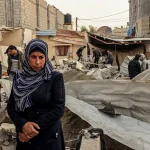Palestinians check a destroyed building following Israeli strikes in Rafah on December 20, 2023. Photo: Said Khatib/AFP.