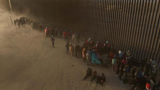 Migrants at border wall waiting to surrender to immigration officials in El Paso, TX, March 25, 2024. Photo: Reuters/Adrees Latif.