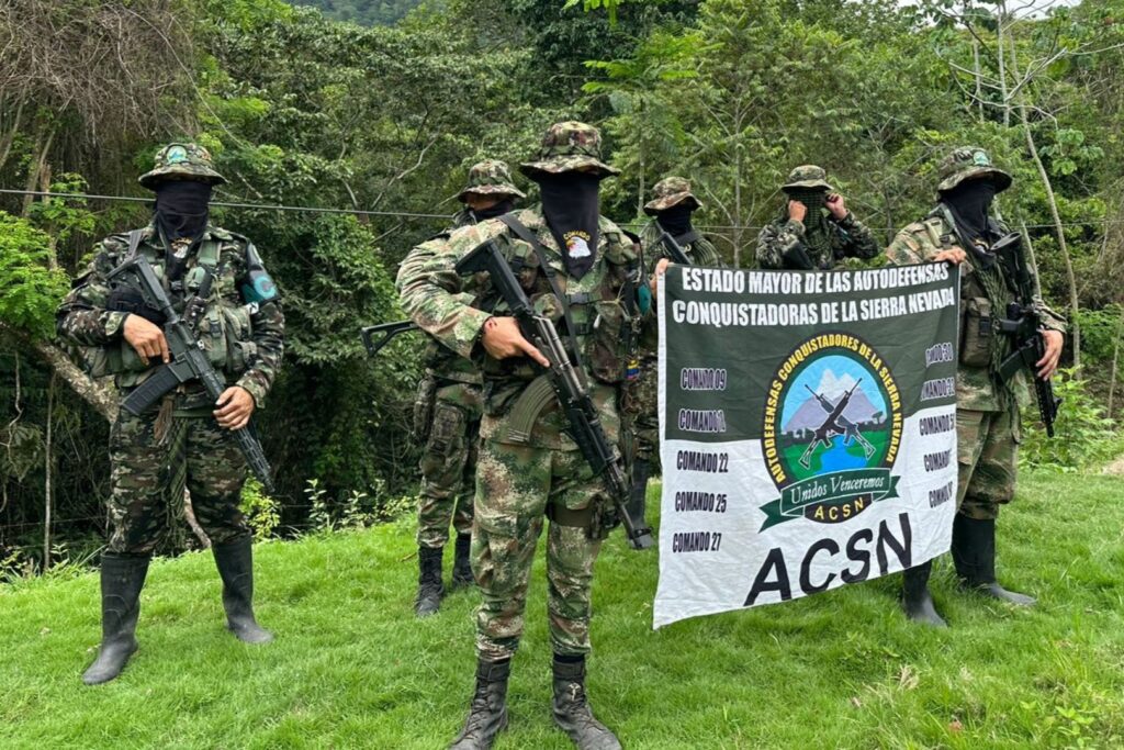 Members of the Colombian paramilitary organization Autodefensas Conquistadoras de la Sierra hold the group's flag during the recording of a video. Photo: X/@ACSN129068.