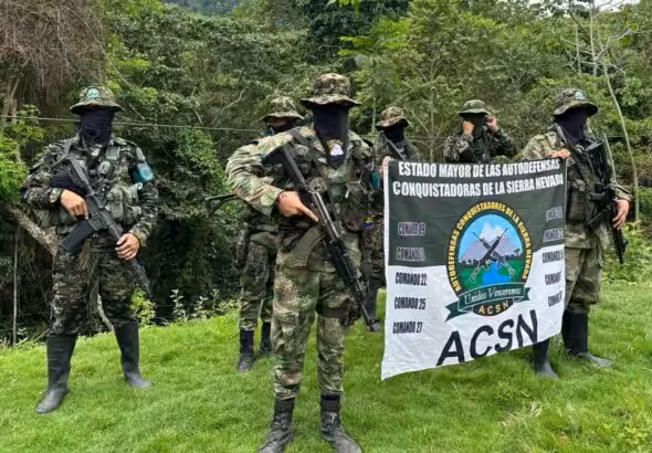 Members of the Colombian paramilitary organization Autodefensas Conquistadoras de la Sierra hold the group's flag during the recording of a video. Photo: X/@ACSN129068.