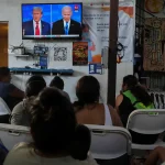 Migrants watch the first debate between US President Joe Biden and former US President and Republican presidential candidate Donald Trump in Tijuana, Mexico, June 27. Photo: Reuters.