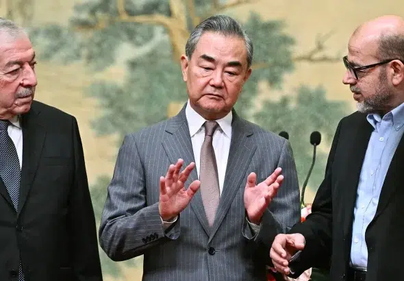 Chinese Foreign Affairs Minister Wang Yi (center) with representatives of the Palestinian delegations to the talks. Photo: Pedro Pardo/AFP.