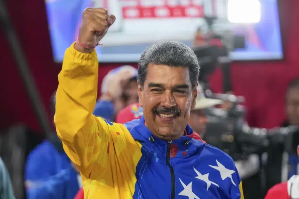 Venezuelan President Nicolás Maduro raises his hand after declared winner of the July 28 presidential election. Photo: AP.