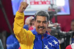 Venezuelan President Nicolás Maduro raises his hand after declared winner of the July 28 presidential election. Photo: AP.