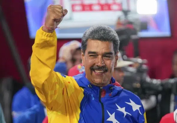 Venezuelan President Nicolás Maduro raises his hand after declared winner of the July 28 presidential election. Photo: AP.