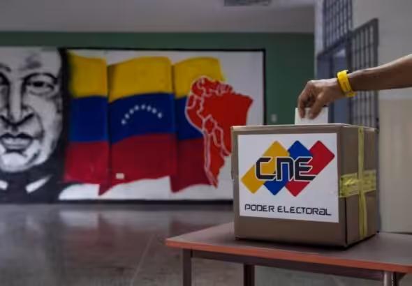 A voter deposits a voting receipt in a Venezuelan polling station. File photo.
