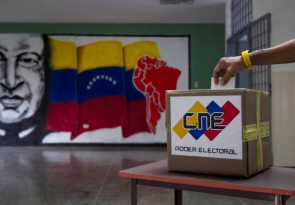 A voter deposits a voting receipt in a Venezuelan polling station. File photo.
