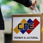 Person casting a paper ballot in a box with the logo of the Venezuelan National Electoral Council (CNE). Photo: File photo.