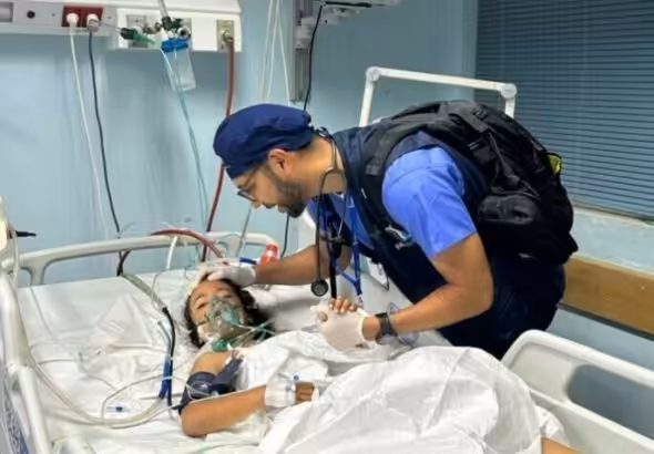 A US doctor treats a child at the European General Hospital in Khan Younis, Gaza. Photo: Usman Shah/Dawn.
