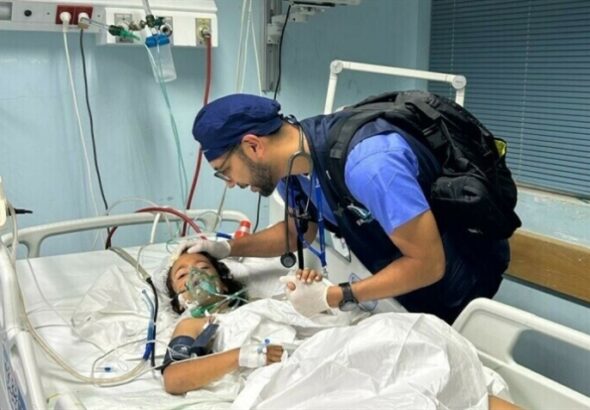 A US doctor treats a child at the European General Hospital in Khan Younis, Gaza. Photo: Usman Shah/Dawn.