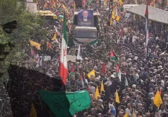 Photo composition showing a massive procession accompanying the remains of Hamas leader Ismail Haniyeh and a watermark of him (left). Photo: The Cradle.