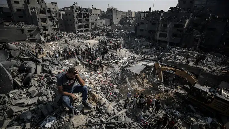 A man sits on debris as Palestinians conduct a search and rescue operation after the second bombardment to the Jabalya refugee camp in Gaza City, on November 1. Photo: Ali Jadallah/Anadolu/Getty Images.