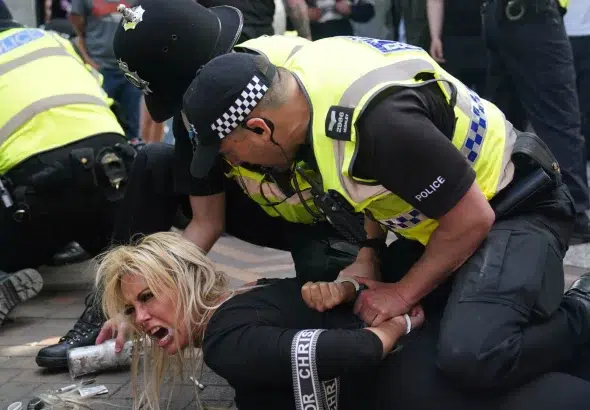 Police officer forcibly handcuffs a woman during a protest in Nottingham, England’s Market Square Saturday Aug. 3, 202. Photo: Jacob King/PA via AP.