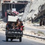 Children sit in the back of a small vehicle as Palestinians flee with their belongings from Deir el-Balah in the central Gaza Strip on August 16, 2024. Photo: AFP.