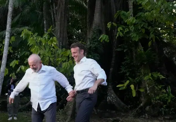 Brazilian President Luiz Inácio Lula da Silva and French President Emmanuel Macron holding hands while visiting Combu Island, Brazil, on March 26. Photo: Eraldo Peres/AP/file photo.