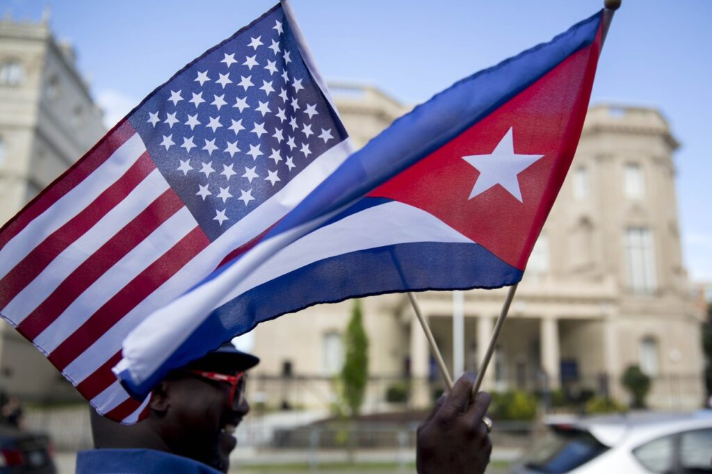 A person holding small US and Cuban flags in front of the Cuban embassy in Washington DC. Photo: Andrew Harrer/Bloomberg/file photo.