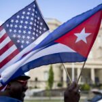 A person holding small US and Cuban flags in front of the Cuban embassy in Washington DC. Photo: Andrew Harrer/Bloomberg/file photo.