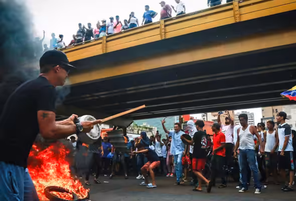 Venezuelan opposition protesters gather round a bonfire. Photo: Misión Verdad.