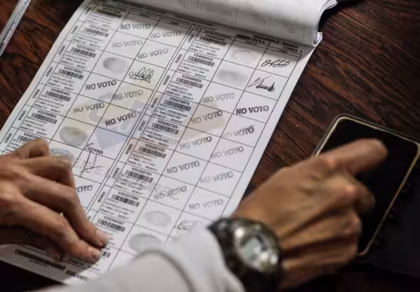 CNE election notebook being filled with a “did not vote” stamp after an election. Photo: EFE/file photo.