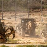 Fenced Israeli occupation bulldozers removing rubbish caused by incessant air strikes on Palestine and its people. Photo: Jack Guez/AFP.