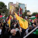 Iranian protesters wave Iranian, Palestinian, and Hezbollah group flags in a demonstration to condemn the killing of Hamas leader Ismail Haniyeh, at Felestin (Palestine) Sq. in Tehran, Iran, Wednesday, July 31, 2024. Photo: AFP.