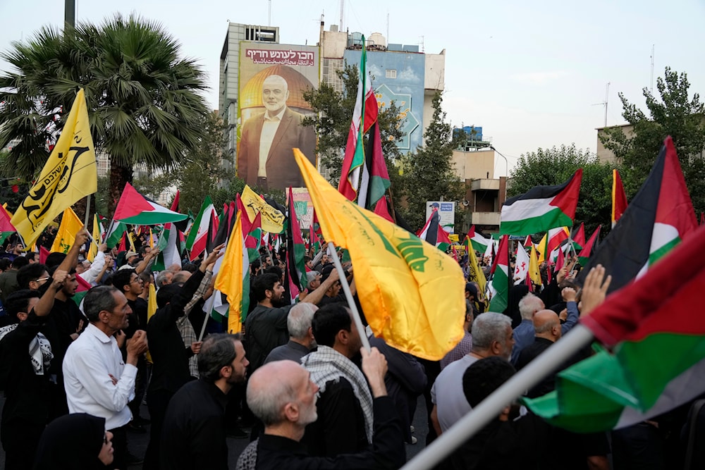 Iranian protesters wave Iranian, Palestinian, and Hezbollah group flags in a demonstration to condemn the killing of Hamas leader Ismail Haniyeh, at Felestin (Palestine) Sq. in Tehran, Iran, Wednesday, July 31, 2024. Photo: AFP.