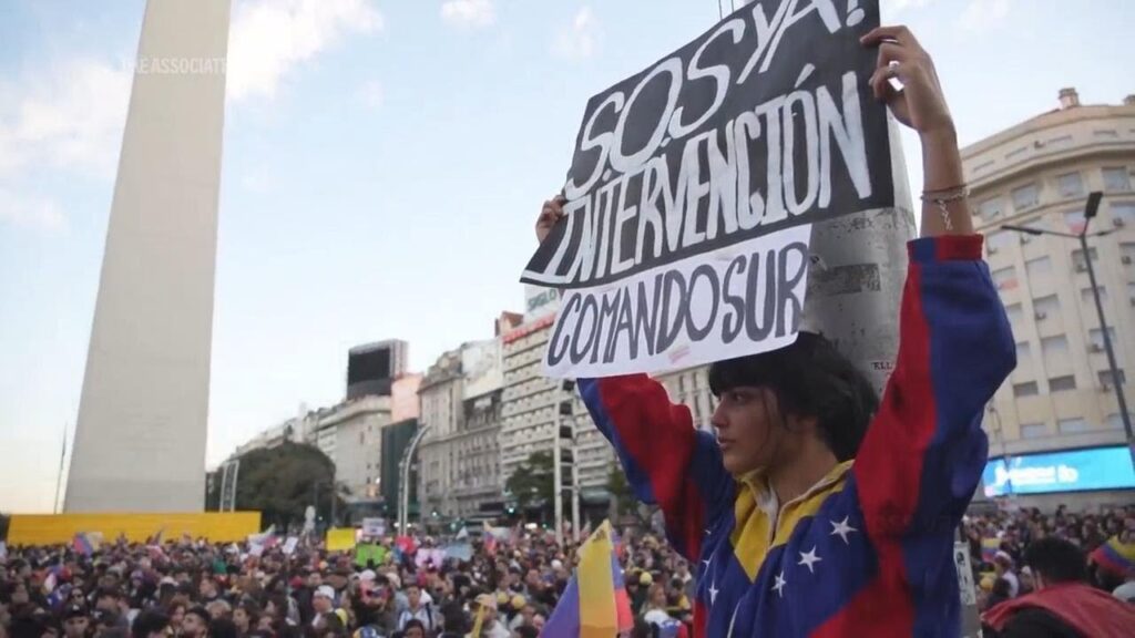 Opposition supporters demonstrating in Buenos Aires one of them holding a banner that reads “SOS, Intervention now, SouthCom.” Photo: AP.