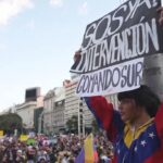 Opposition supporters demonstrating in Buenos Aires one of them holding a banner that reads “SOS, Intervention now, SouthCom.” Photo: AP.