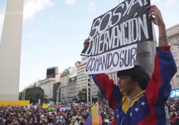 Opposition supporters demonstrating in Buenos Aires one of them holding a banner that reads “SOS, Intervention now, SouthCom.” Photo: AP.