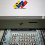 Venezuelan voting machine next to an instructional poster for the July 28 presidential elections. Photo: El Pais.