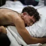 A Palestinian mourns a loved one killed in an Israeli attack, Al-Aqsa Martyrs Hospital, central Gaza Strip, 12 August. Photo: Saher Alghorra/ZUMA Press Wire.