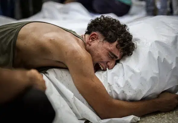 A Palestinian mourns a loved one killed in an Israeli attack, Al-Aqsa Martyrs Hospital, central Gaza Strip, 12 August. Photo: Saher Alghorra/ZUMA Press Wire.