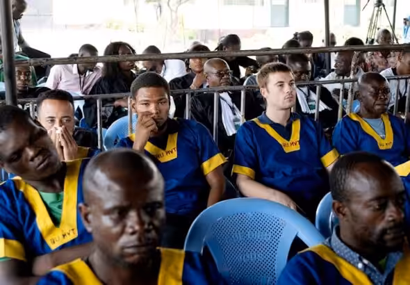 Along the back row shows from left; Benjamin Reuben Zalman-Polun, Marcel Malanga, and Tyler Thompson, all American citizens, attend a court verdict in Congo, Kinshasa, Friday, Sept. 13, 2024, on charges of taking part in a coup attempt in May 2024. Photo: Al Mayadeen.