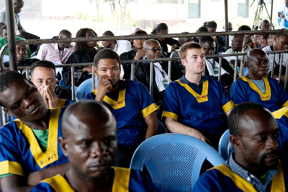 Along the back row shows from left; Benjamin Reuben Zalman-Polun, Marcel Malanga, and Tyler Thompson, all American citizens, attend a court verdict in Congo, Kinshasa, Friday, Sept. 13, 2024, on charges of taking part in a coup attempt in May 2024. Photo: Al Mayadeen.