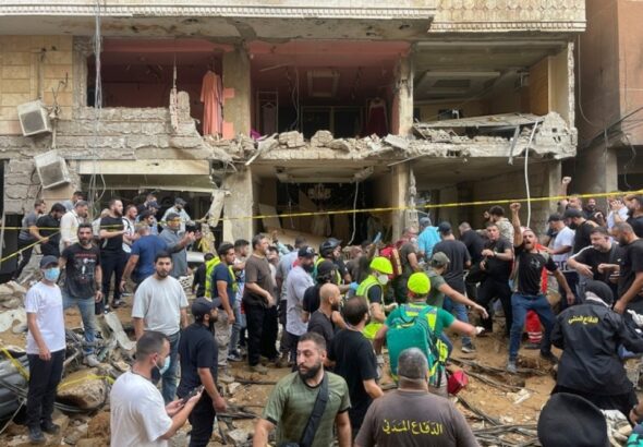People gather near a damaged building at the scene of an Israeli missile strike in the Southern Suburb of Beirut on Friday, September 20, 2024. Photo: AP.