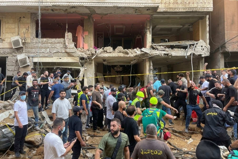 People gather near a damaged building at the scene of an Israeli missile strike in the Southern Suburb of Beirut on Friday, September 20, 2024. Photo: AP.