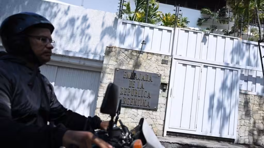 A biker passing by the entrance of the Argentinian embassy in Caracas. Photo: AFP.