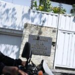 A biker passing by the entrance of the Argentinian embassy in Caracas. Photo: AFP.