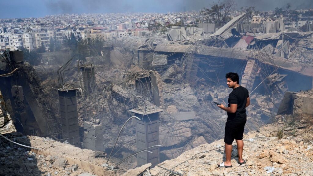 A person looking at the destruction in the place where Hezbollah Secretary-General Hassan Nasrallah was assassinated in Choueifat, southeast of Beirut, Lebanon. Photo: AP.