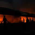 Palestinians try to extinguish a fire caused by Israeli airstrikes on tents in the courtyard of Al-Aqsa Martyrs Hospital, Deir al-Balah, central Gaza Strip, October 14, 2024. Photo: AP.